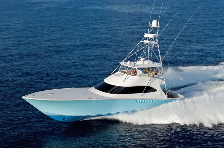 A sportfishing game boat running at speed, outriggers up